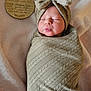 Wrenleigh is registered to the contest to win money with this photo: newborn, baby, swaddled, bow_headband, blanket, wooden_disc, milestone_disc, puckered_lips, sleeping, portrait, cozy, soft_texture, fabric_pattern, face, head, skin, indoor, cute, laying, neutral_tones