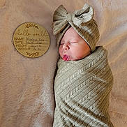 Wrenleigh is registered to the contest to win money with this photo: newborn, baby, infant, swaddle, headwrap, bow, blanket, milestone_disc, wooden_plaque, sleeping, tongue_out, portrait, cozy, soft_texture, nursery, cute, newborn_photoshoot, plush, fabric, peaceful
