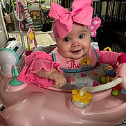 Cheyenne joined the competition — help win amazing prizes! baby, baby_walker, carpet, child, cushion, cute, face, furniture, happy, headband, indoor, infant, living_room, person, pink_bow, pink_clothing, plants, portrait, smiling, toys