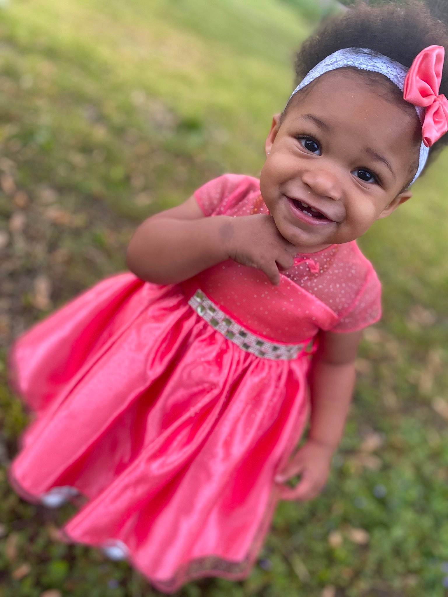 Zaniyah is registered to the contest to win money with this photo: arm, baby_toddler_clothing, botany, dress, eye, face, finger, flash_photography, grass, happy, head, joy, magenta, meadow, people_in_nature, person, pink, plant, skin, sleeve