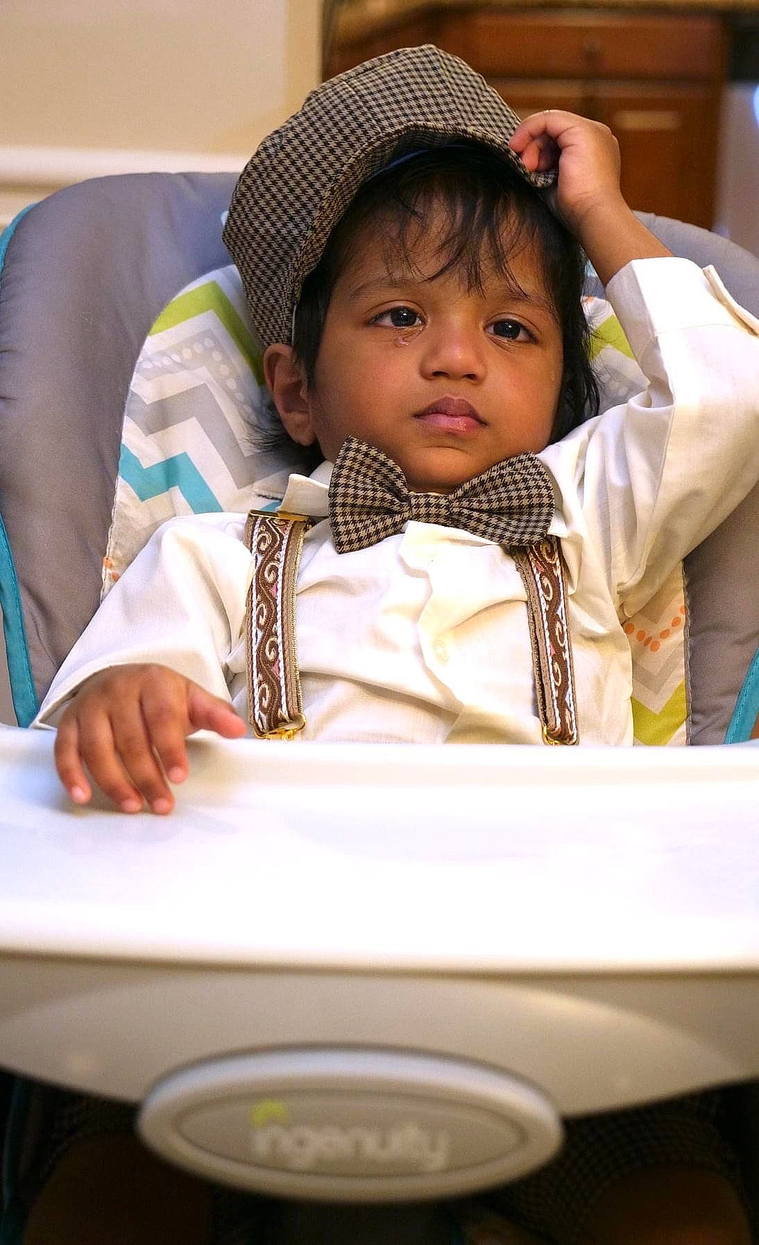 Evan is registered to the contest to win money with this photo: baby, cheek, child, comfort, drinkware, eyebrow, fashion_accessory, fun, happy, hat, mouth, nose, person, portrait_photography, room, sitting, skin, sleeve, sun_hat, toddler