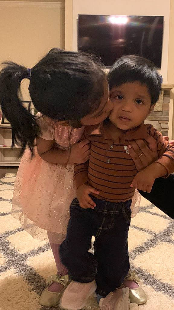 Evan is registered to the contest to win money with this photo: adaptation, baby, child, event, facial_expression, flooring, foot, friendship, fun, gesture, happy, interaction, leg, person, sandal, shoulder, sitting, skin, standing, toddler