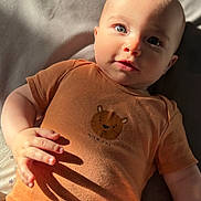 Matteo a rejoint le concours — aidez-le/la à gagner de superbes lots ! baby, brown_clothing, child, cute, expression, eyes, fabric, face, hand_shadow, indoor, infant, lying_down, onesie, person, portrait, skin, soft_texture, sunlight, tiger_graphic, wild_one_text