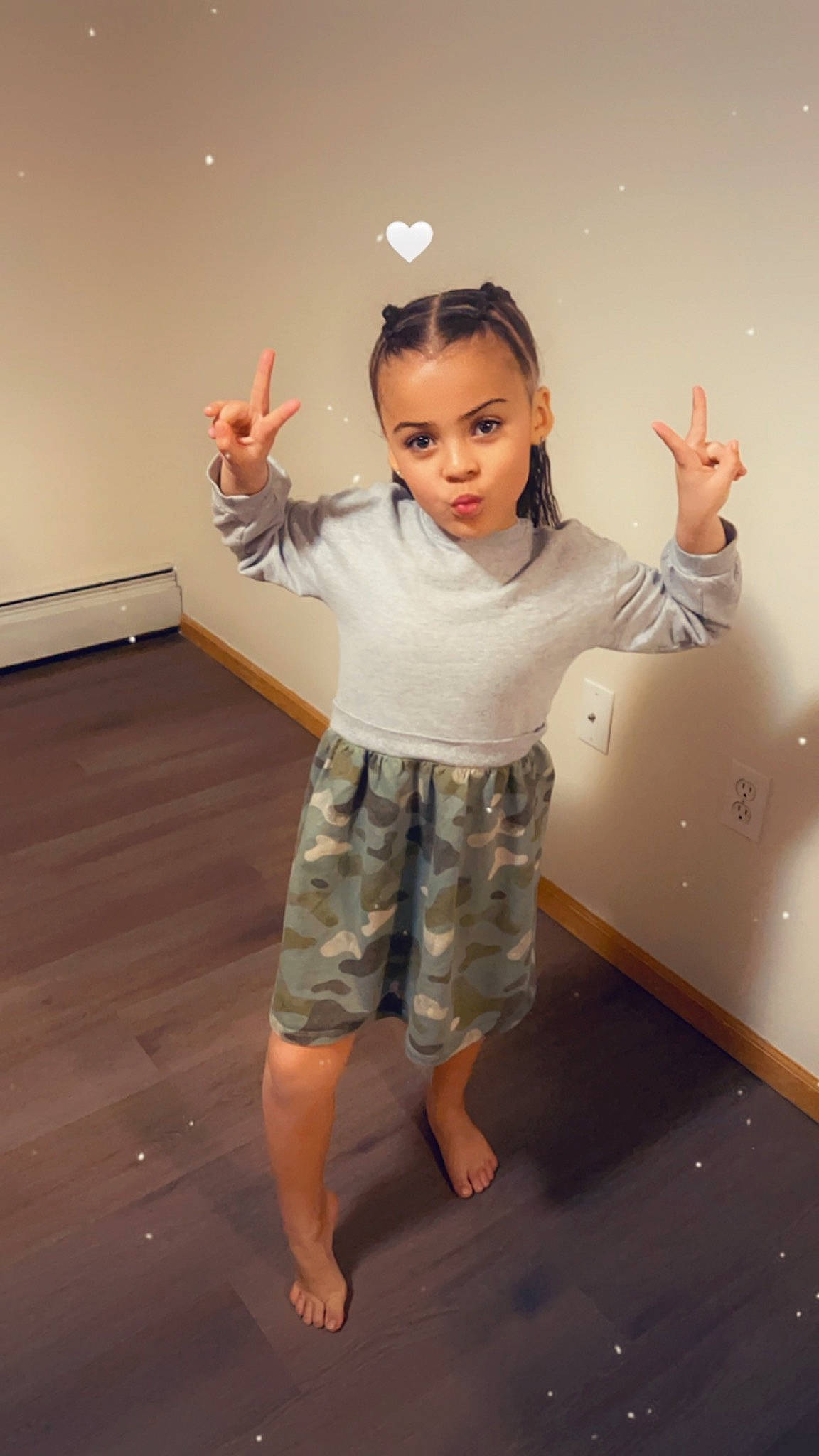 Tazlynn is registered to the contest to win money with this photo: baby_toddler_clothing, barefoot, child, elbow, flooring, fun, gesture, hairstyle, happy, human_leg, joint, knee, pattern, person, shoulder, sleeve, standing, t_shirt, thumb, toddler