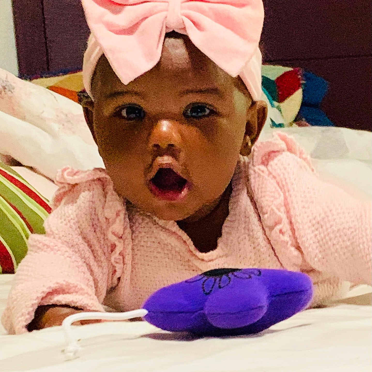 Alexandria joined the competition — help win amazing prizes! baby, bed, child, childhood, cozy, curious, cute, expression, face, headband, indoor, infant, person, pillow, pink_bow, pink_sweater, plush_toy, purple_toy, soft_toy, surprised