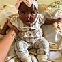 Alexandria joined the competition — help win amazing prizes! baby, child, infant, pink_bow, headband, striped_outfit, socks, blanket, hand, tattoo, indoor, person, cute, expression, curious, seated, soft_texture, cozy, skin, adult_hand