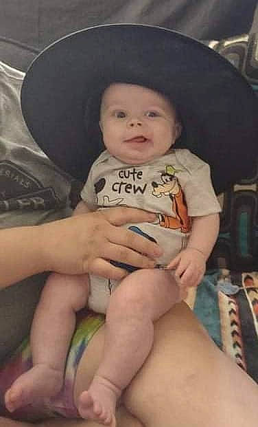 Owen Wyatt is registered to the contest to win money with this photo: baby, cheek, comfort, eye, face, fedora, finger, fun, hat, head, headwear, knee, lap, leg, mouth, organ, person, skin, smile, sun_hat