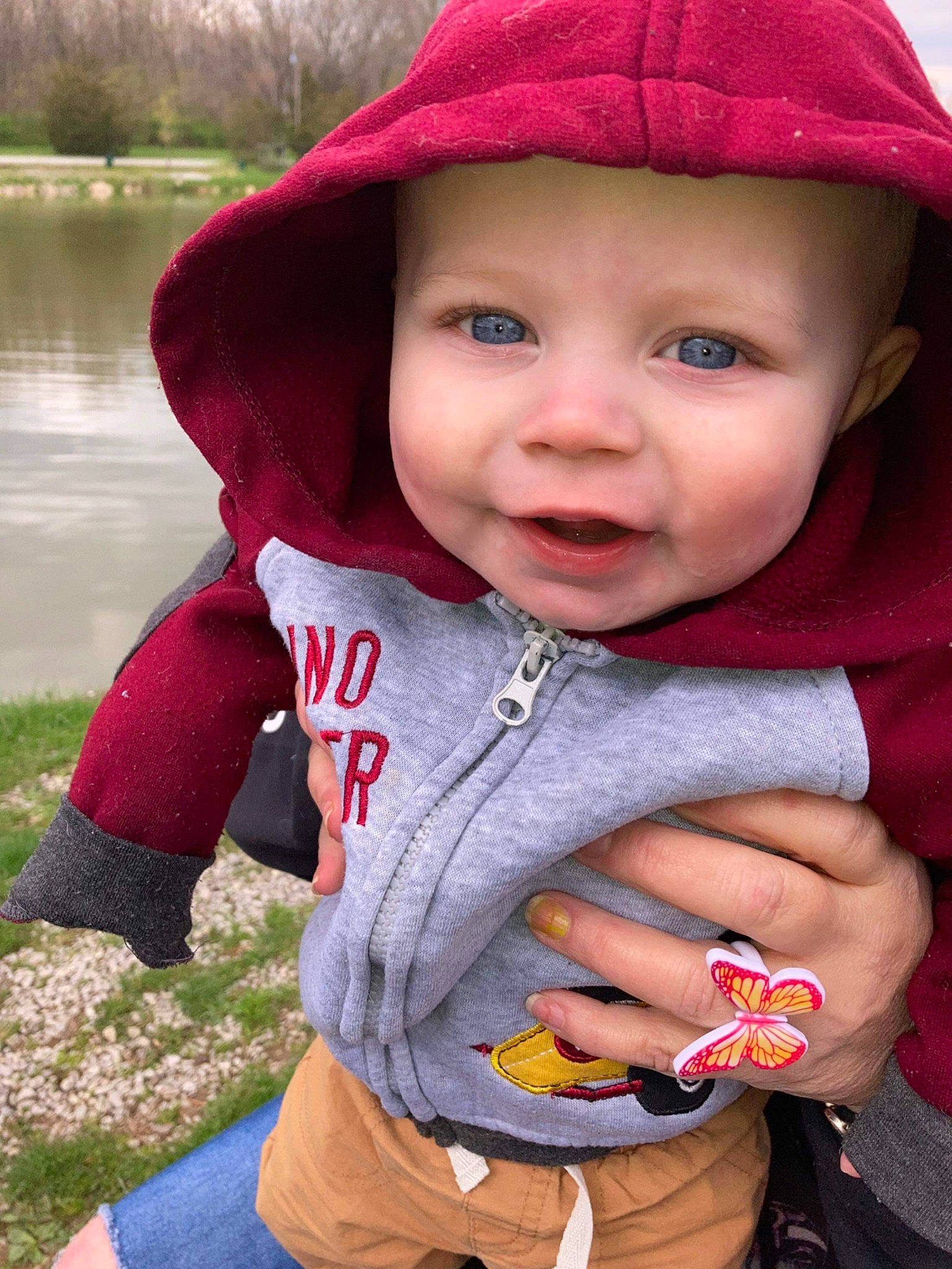 Owen joined the competition — help win amazing prizes! baby, baby_toddler_clothing, cap, face, fun, grass, happy, headwear, lake, lip, magenta, mouth, outerwear, person, pink, plant, red, skin, sleeve, smile