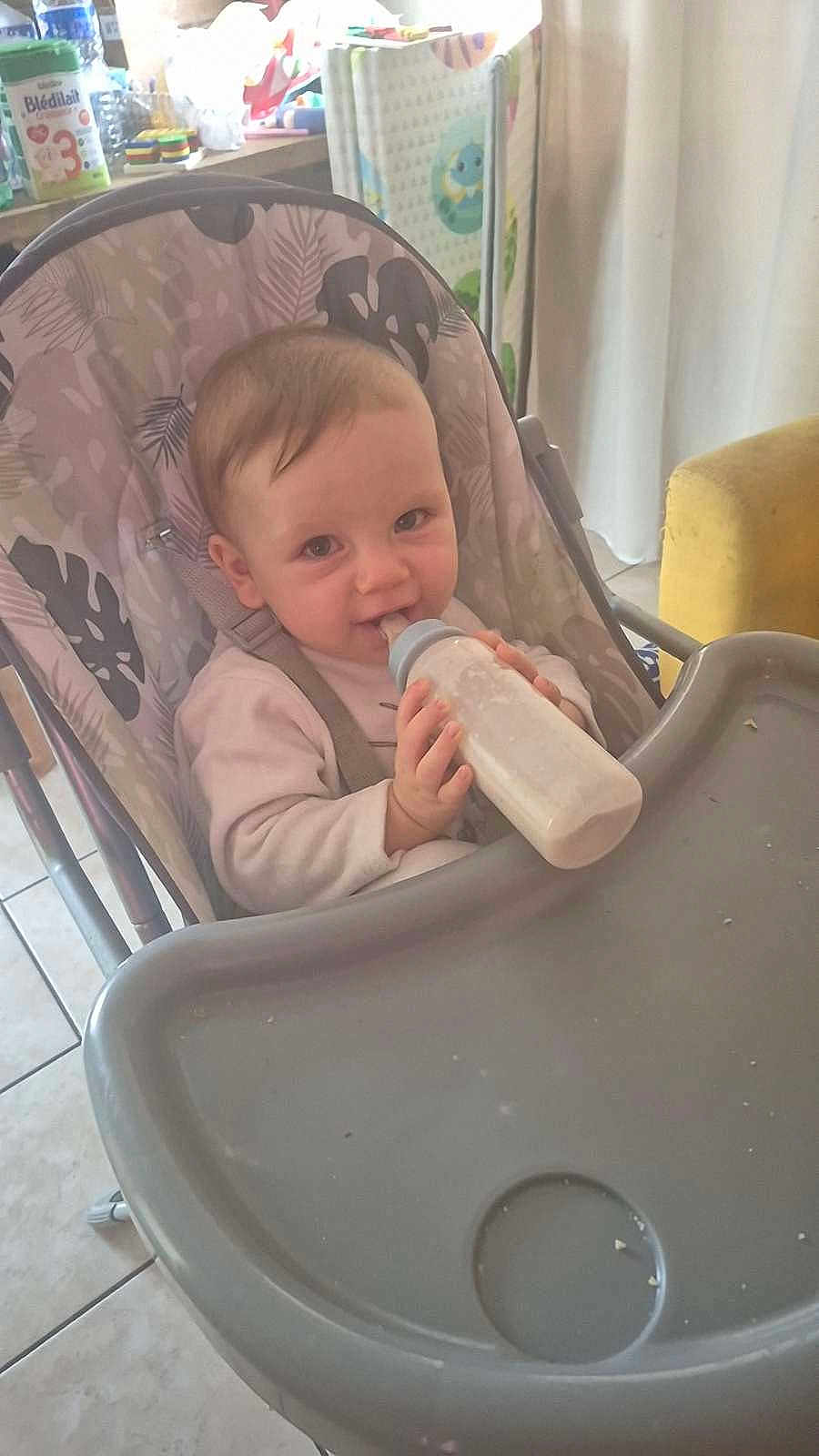 Memphis participe au concours pour gagner de l'argent avec cette photo : baby, bottle, high_chair, milk, infant, kitchen, feeding, child, smiling, indoor, person, seat, cute, hands, table, tile_floor, curtains, toy, container, food