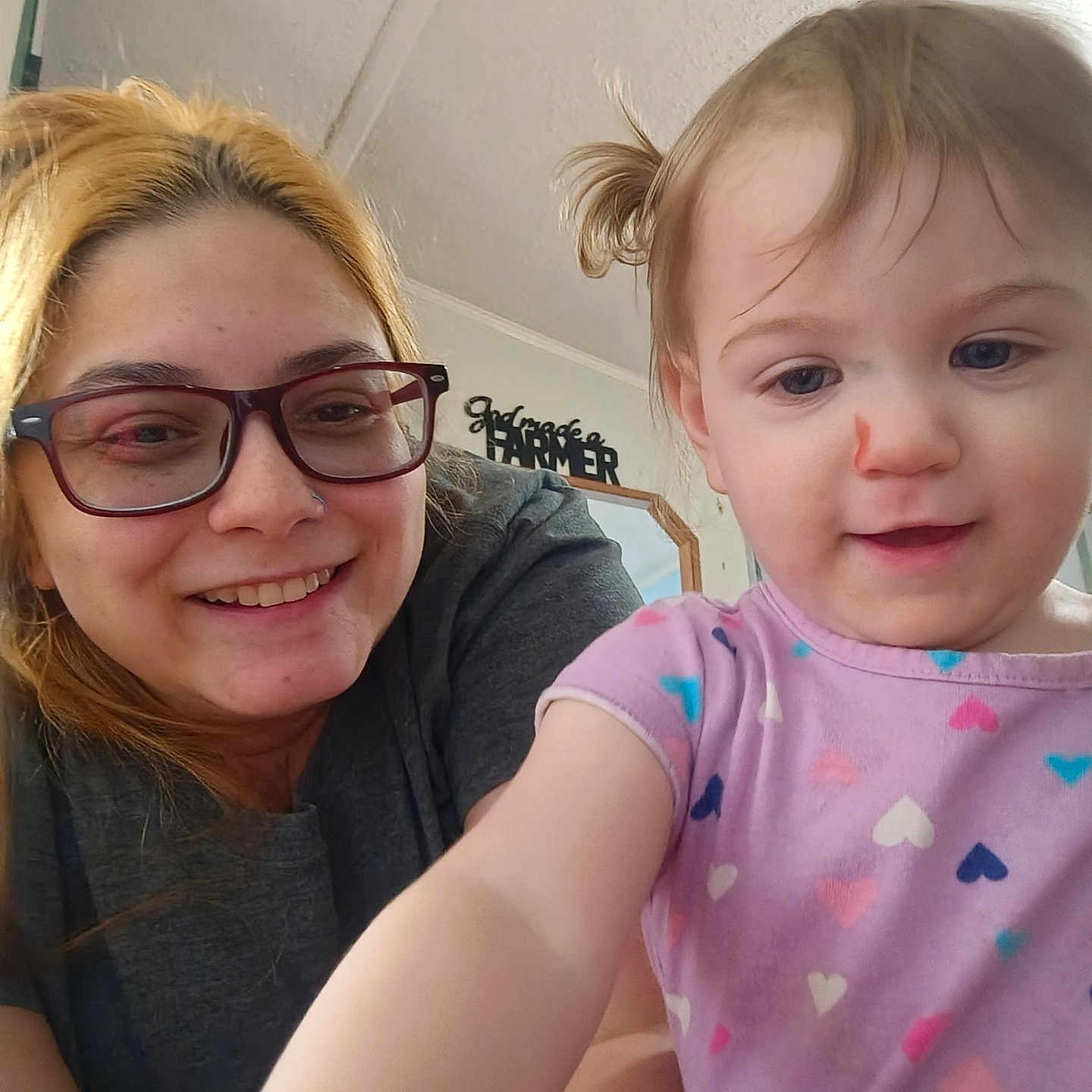 Freya joined the competition — help win amazing prizes! woman, child, toddler, glasses, smile, indoor, mirror, wall_decor, heart_pattern, shirt, casual_clothing, person, face, happy, curious, blond_hair, hair_tied, skin, closeup, family