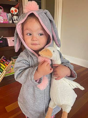 Calliope is registered to the contest to win money with this photo: baby, baby_toddler_clothing, cap, cheek, child, comfort, eye, eyelash, gesture, happy, head, headgear, nose, outerwear, person, pink, shelf, skin, smile, textile