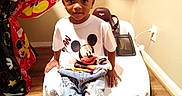 Ayan is registered to the contest to win money with this photo: child, toddler, mickey_mouse, toy_car, balloons, birthday_party, jeans, tshirt, sneakers, indoor, wood_floor, decorations, table, chair, person, smiling, cute, celebration, play, fun