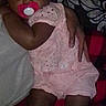 Egypt is registered to the contest to win money with this photo: baby, child, pacifier, pink_outfit, socks, person, indoor, couch, blanket, pattern, holding, comfort, cute, infant, footwear, resting, closeup, human, toddler, family