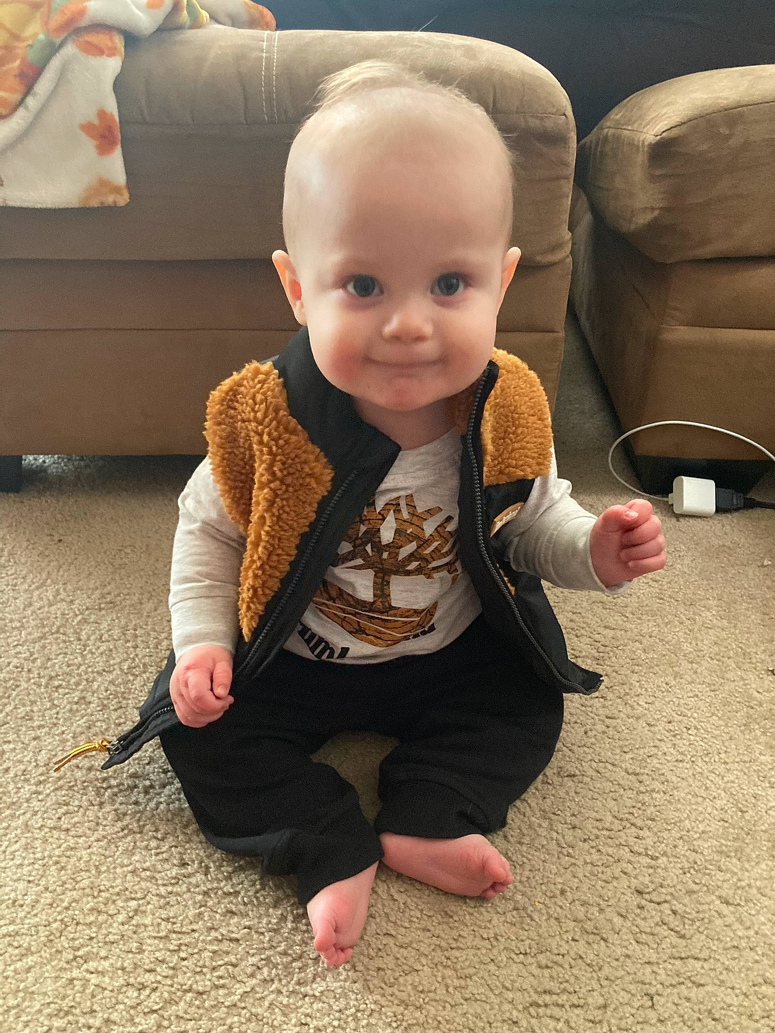 Leighton is registered to the contest to win money with this photo: baby, baby_toddler_clothing, carpet, cheek, child, comfort, couch, floor, flooring, fur, happy, head, human_body, joy, person, sitting, skin, sleeve, smile, toddler
