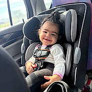 Penelope joined the competition — help win amazing prizes! toddler, child, baby, smiling, happy, car, car_seat, seatbelt,  안전, passenger, indoors, vehicle, portrait, curly_hair, hair_bun, pink_clothing, white_shirt, black_pants, sunlight, road_trip