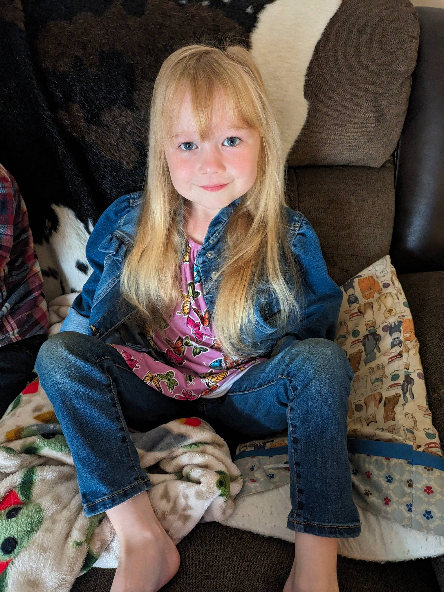 Izzy is registered to the contest to win money with this photo: child, comfort, denim, face, fawn, finger, hair, hairstyle, head, human_leg, jeans, knee, lap, leg, long_hair, person, skin, smile, thigh, toddler