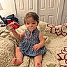 baby, child, pacifier, blue_dress, quilt, blanket, indoor, sitting, holding, carton, foot, hand, face, hair, room, door, furniture, cozy, cute, infant
