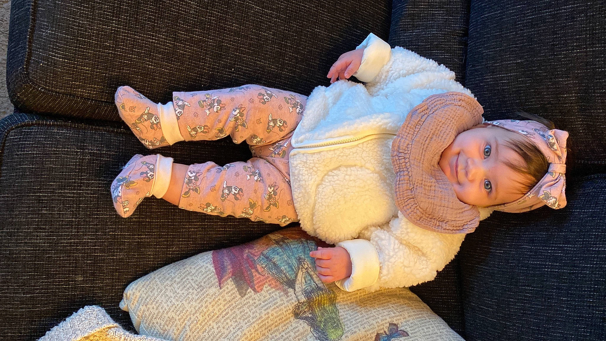 Emma is registered to the contest to win money with this photo: abdomen, baby, baby_toddler_clothing, child, comfort, fun, hat, headgear, human_leg, lap, linens, pattern, person, pink, sitting, smile, textile, thigh, toddler, tree