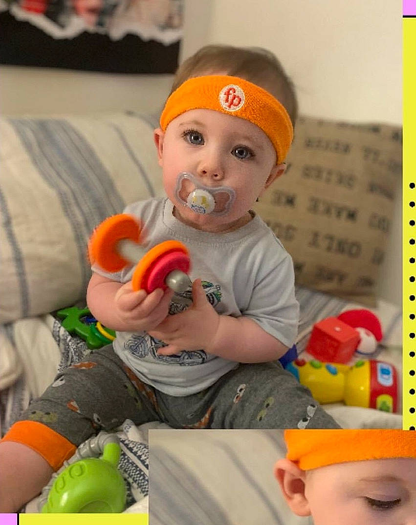 Kieran is registered to the contest to win money with this photo: baby, baby_playing_with_toys, baby_toddler_clothing, cap, child, couch, event, facial_expression, fun, happy, headgear, orange, people, person, photograph, room, sitting, t_shirt, toddler, toy