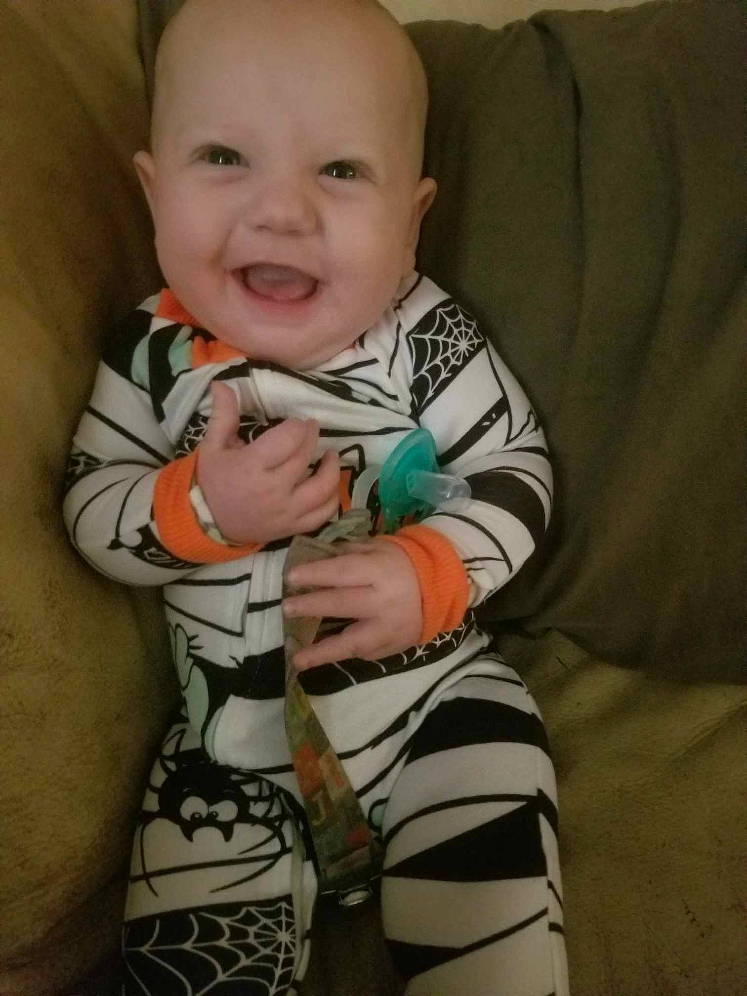 Lotus'Marie is registered to the contest to win money with this photo: arm, baby, baby_toddler_clothing, cheek, child, comfort, elbow, eye, face, finger, iris, person, skin, sleeve, smile, standing, t_shirt, textile, thigh, toddler