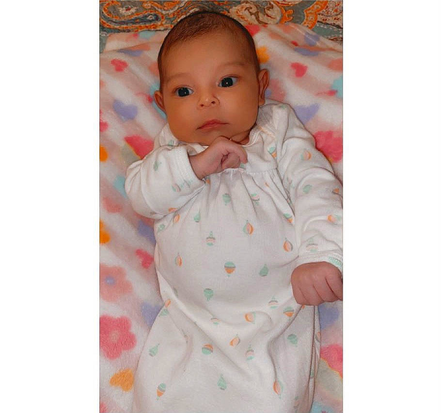 Amina is registered to the contest to win money with this photo: baby, baby_products, baby_sleeping, baby_toddler_clothing, cheek, child, clothing, collar, comfort, face, happy, head, linens, neck, outerwear, pattern, peach, person, sitting, sleeve