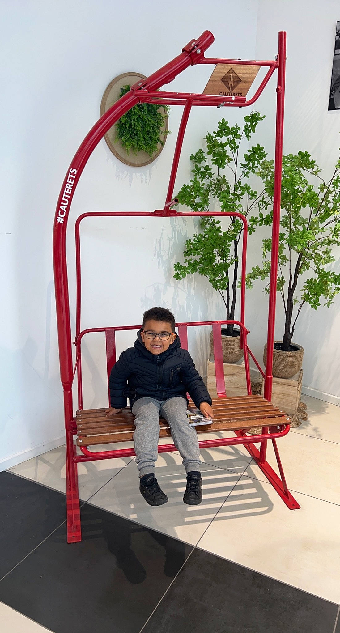 Kaiss participe au concours pour gagner de l'argent avec cette photo : balance, child, comfort, flooring, flowerpot, fun, houseplant, joy, leisure, outdoor_furniture, outdoor_play_equipment, person, plant, recreation, red, room, symmetry, t_shirt, toddler