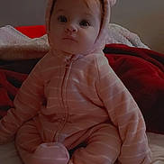 Ashlynn joined the competition — help win amazing prizes! baby, bed, blanket, child, clothing, cozy, cute, ears, face, hood, indoor, infant, looking, person, pink_onesie, portrait, sitting, soft, warm, young