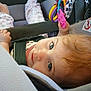 Ashlynn joined the competition — help win amazing prizes! baby, child, car_seat, toy, colorful_toy, blue_eyes, curly_hair, straps, safety, infant, cute, looking_up, indoor, seatbelt, fabric, patterned_clothing, hand, feet, closeup, portrait