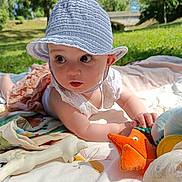 Aria participe au concours pour gagner de l'argent avec cette photo : baby, hat, plush_toy, starfish, blanket, outdoor, grass, sunlight, child, wide_eyes, curious, summer, nature, toy, cuteness, soft_toy, playtime, portrait, infant, relaxing