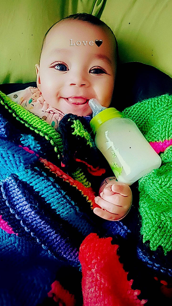 Amina is registered to the contest to win money with this photo: baby, baby_toddler_clothing, beauty, cheek, child, eyelash, fun, green, happy, iris, organ, people_in_nature, person, photograph, plastic_bottle, skin, smile, textile, toddler, toy