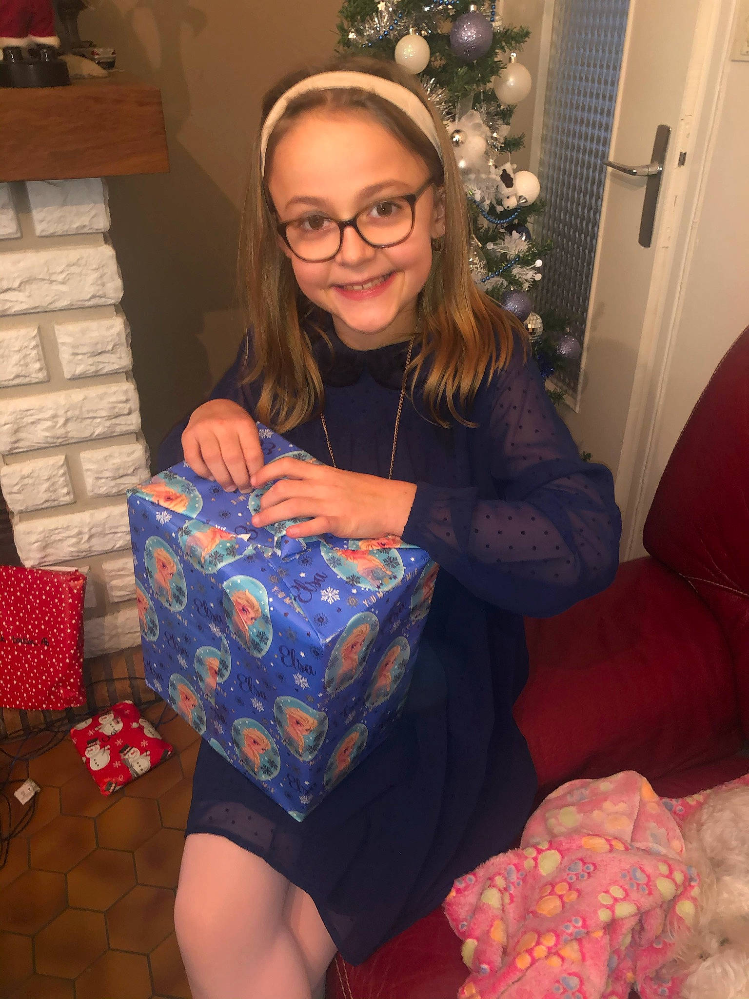 Léna a rejoint le concours — aidez-le/la à gagner de superbes lots ! christmas, christmas_decoration, christmas_eve, christmas_ornament, door, foot, gift_wrapping, glasses, holiday, holiday_ornament, home, interior_design, joy, lap, living_room, opening_presents, ornament, person, present, room