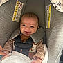 baby, blanket, car_seat, child, clothing, cozy, cute, happy, head_support, indoor, infant, person, portrait, safety, seatbelt, secure, smiling, striped_clothing, toddler, young_child