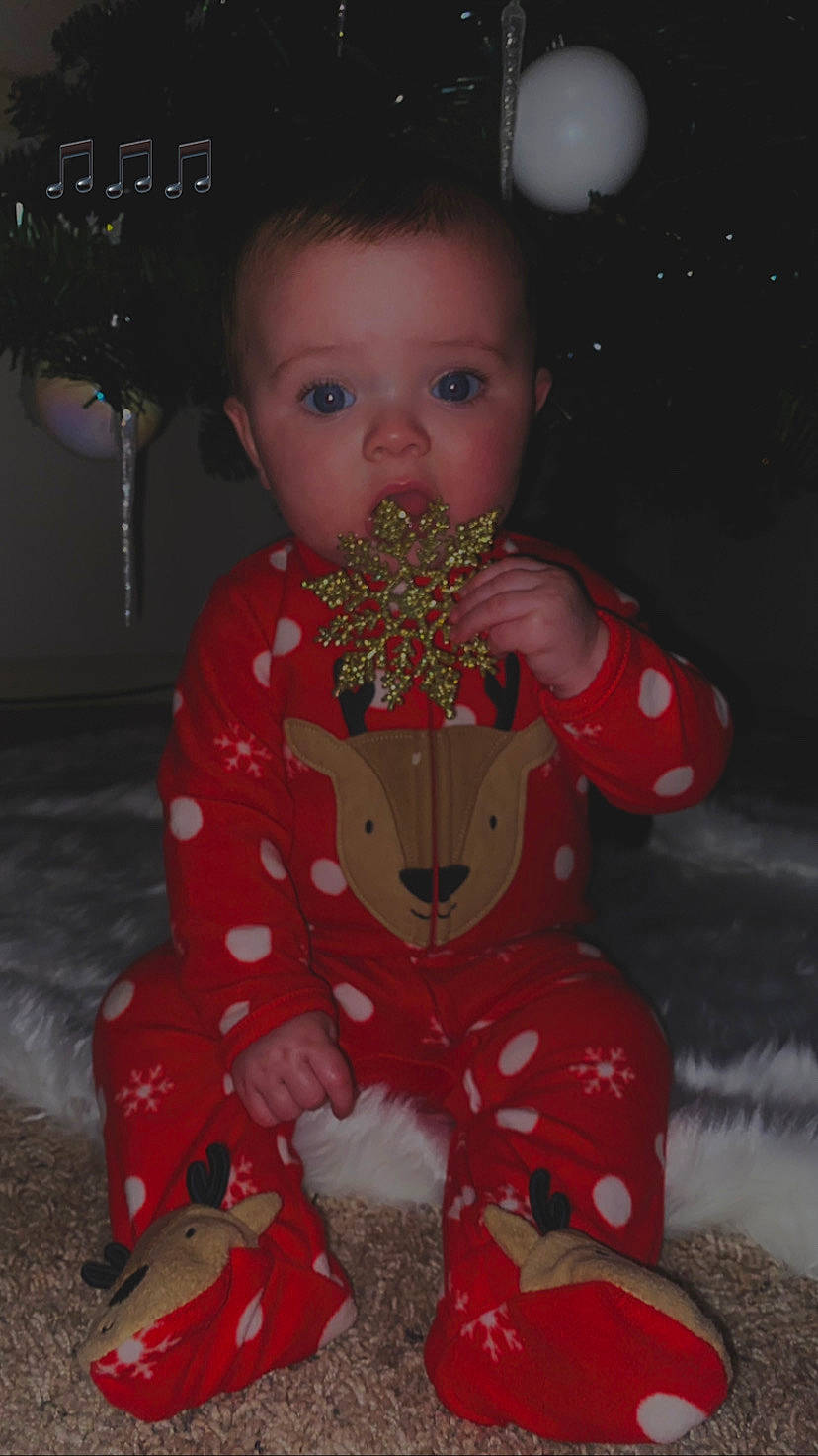 Addyson joined the competition — help win amazing prizes! baby, baby_toddler_clothing, carmine, cheek, child, christmas, christmas_ornament, dress, event, fun, happy, head, holiday, nightwear, nose, pajamas, pattern, person, sitting, sleeve