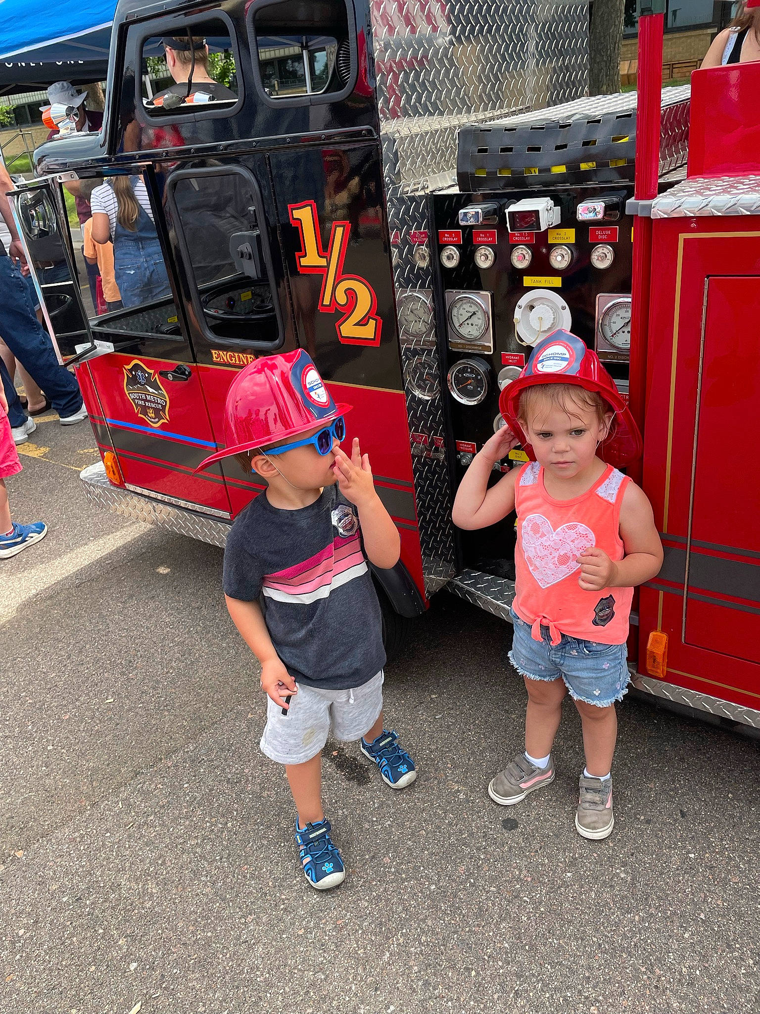 Brynn is registered to the contest to win money with this photo: asphalt, automotive_design, automotive_exterior, child, event, footwear, fun, hat, headwear, leisure, mode_of_transport, motor_vehicle, pedestrian, person, shorts, street, sun_hat, sunglasses, t_shirt, tire