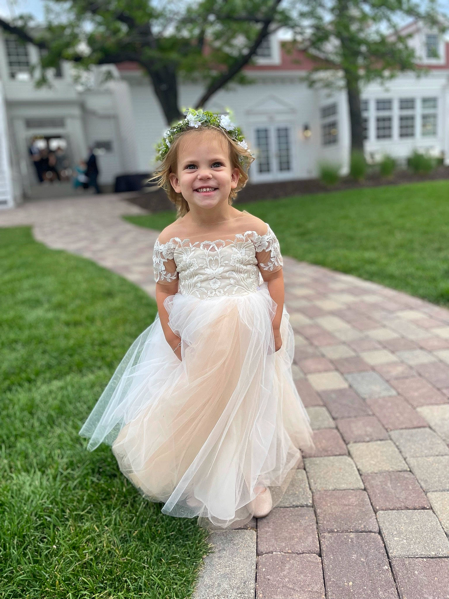 Brynn is registered to the contest to win money with this photo: bridal_accessory, bridal_clothing, bridal_party_dress, clothing, dress, eye, flash_photography, flooring, formal_wear, gown, grass, happy, headgear, headpiece, joy, person, plant, smile, toddler, tree