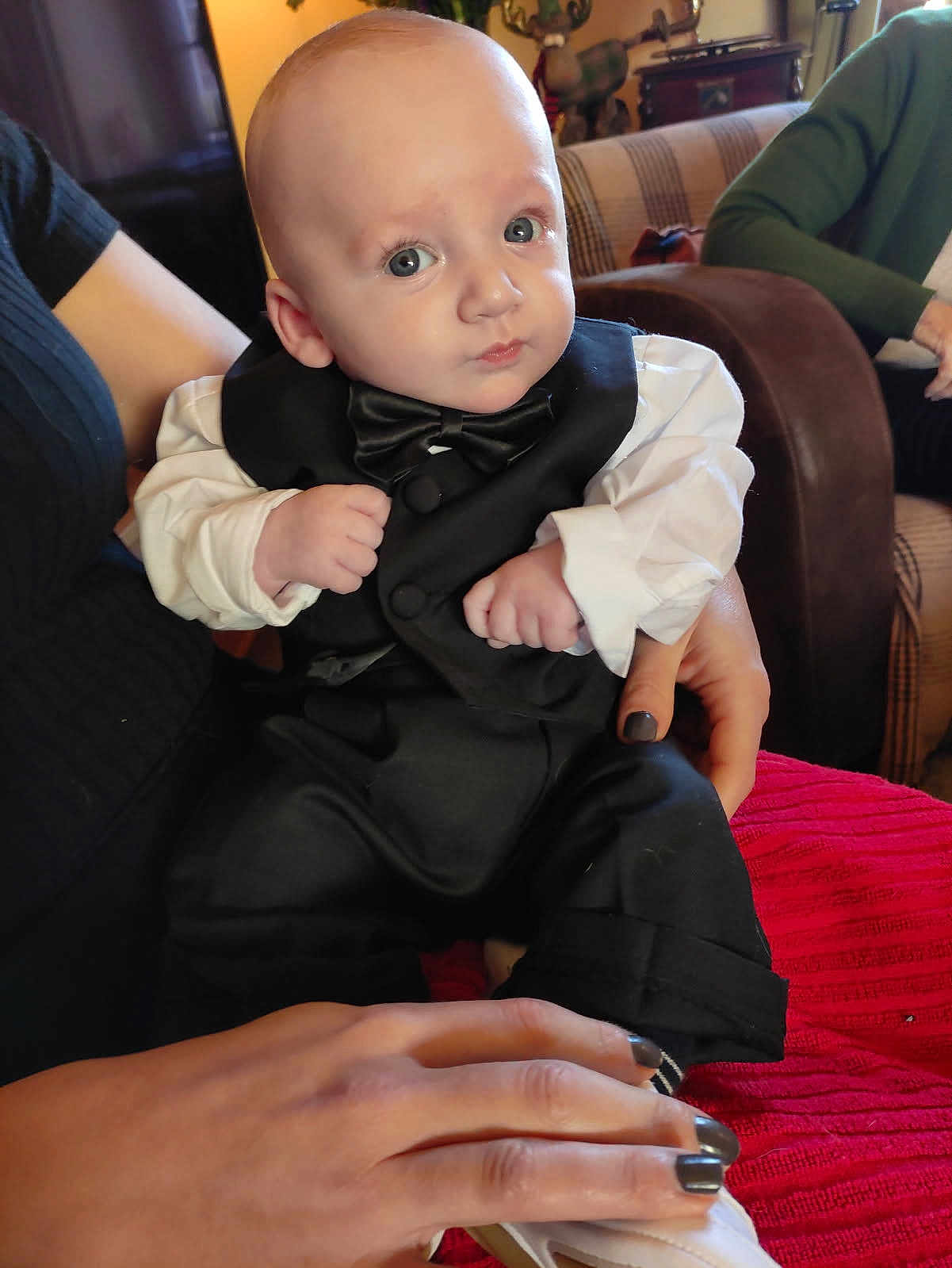 Dario a rejoint le concours — aidez-le/la à gagner de superbes lots ! baby, tuxedo, bow_tie, person, hand, indoor, couch, clothing, child, portrait, sitting, cute, face, infant, adult_hand, home, fashion, black_clothing, white_shirt, footwear