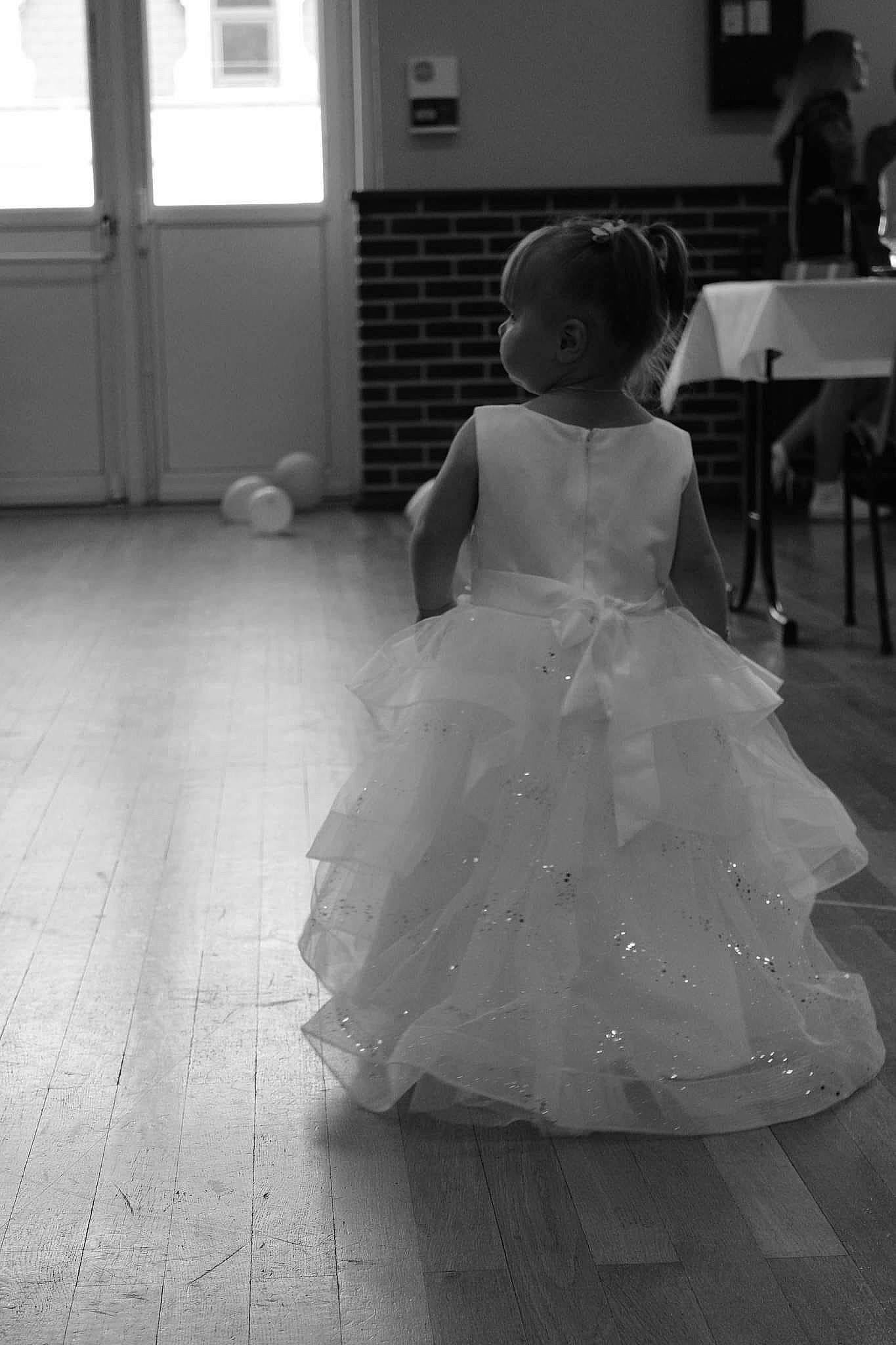 Lya participe au concours pour gagner de l'argent avec cette photo : black, black_and_white, bridal_accessory, bridal_clothing, bridal_party_dress, dress, flash_photography, floor, flooring, gesture, gown, happy, joint, monochrome, person, shoulder, standing, style, toddler, under_exposed