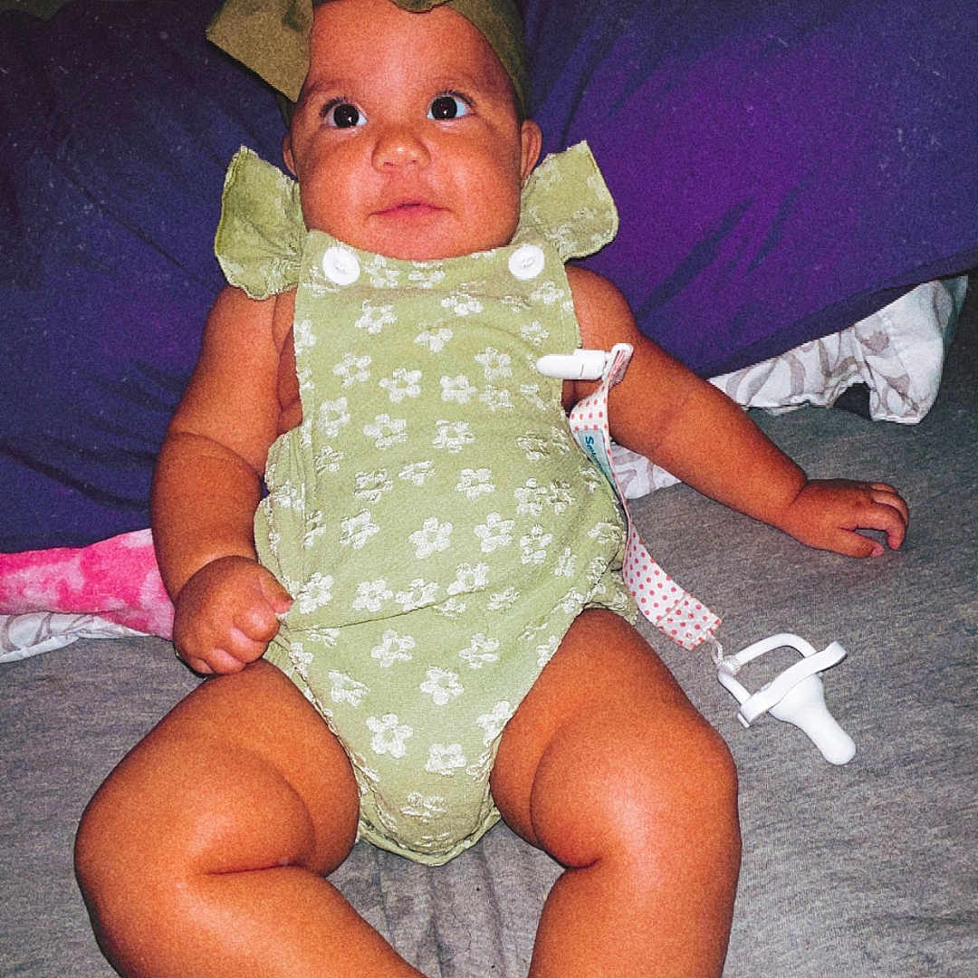 Addelyn joined the competition — help win amazing prizes! baby, bed, child, clothing, cute, expression, feet, hand, headband, human, indoor, infant, laying_down, legs, pacifier, pillow, portrait, romper, skin, young