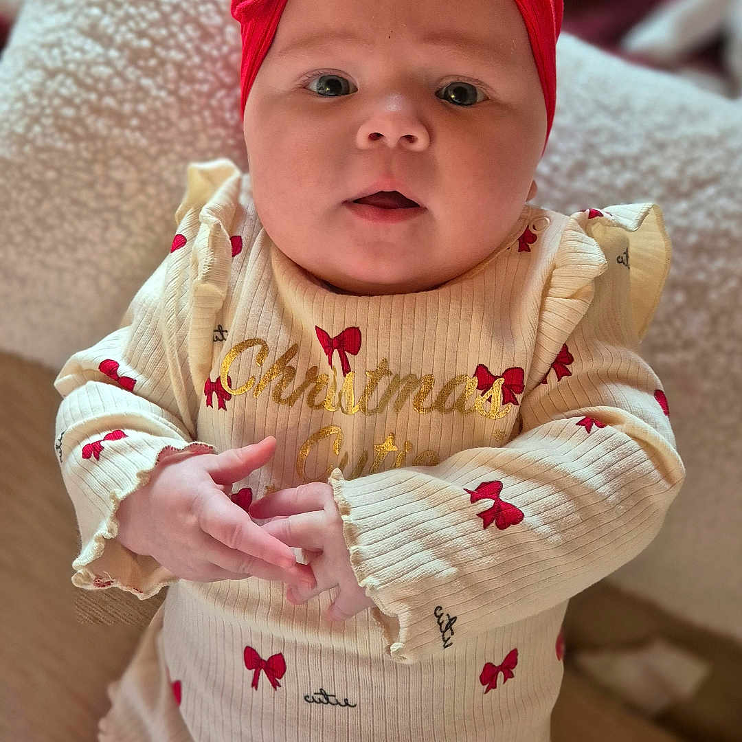 Aleri joined the competition — help win amazing prizes! baby, child, christmas, closeup, clothing, cozy, cream_sweater, cute, cute_outfit, expression, face, hands, holiday, indoors, infant, portrait, red_bows, red_headband, sitting, soft_focus
