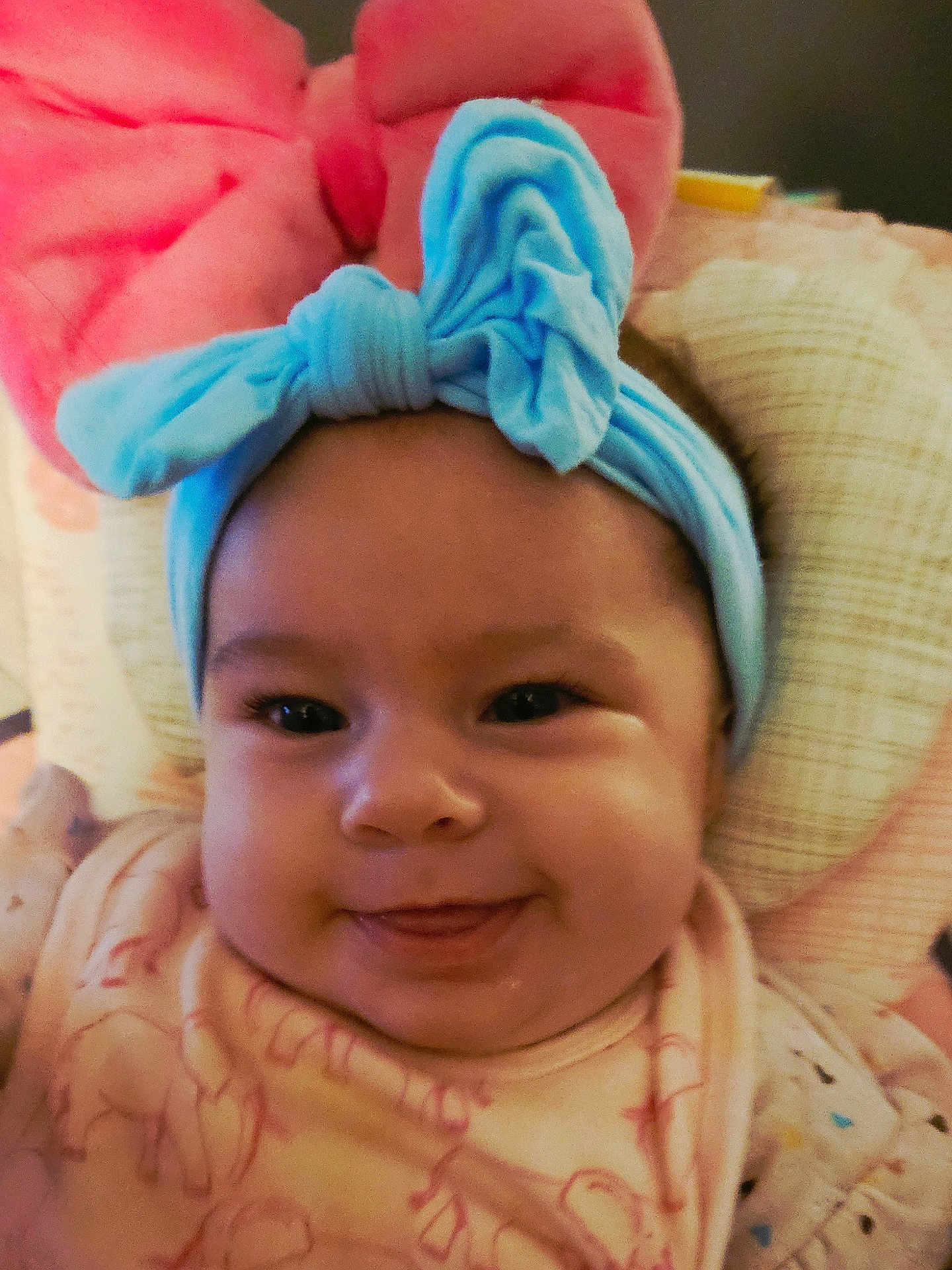 Skylar joined the competition — help win amazing prizes! baby, child, face, headband, bow, smiling, tongue, cute, infant, clothing, pattern, cushion, indoor, portrait, closeup, happy, young_child, headwear, soft_toys, cozy