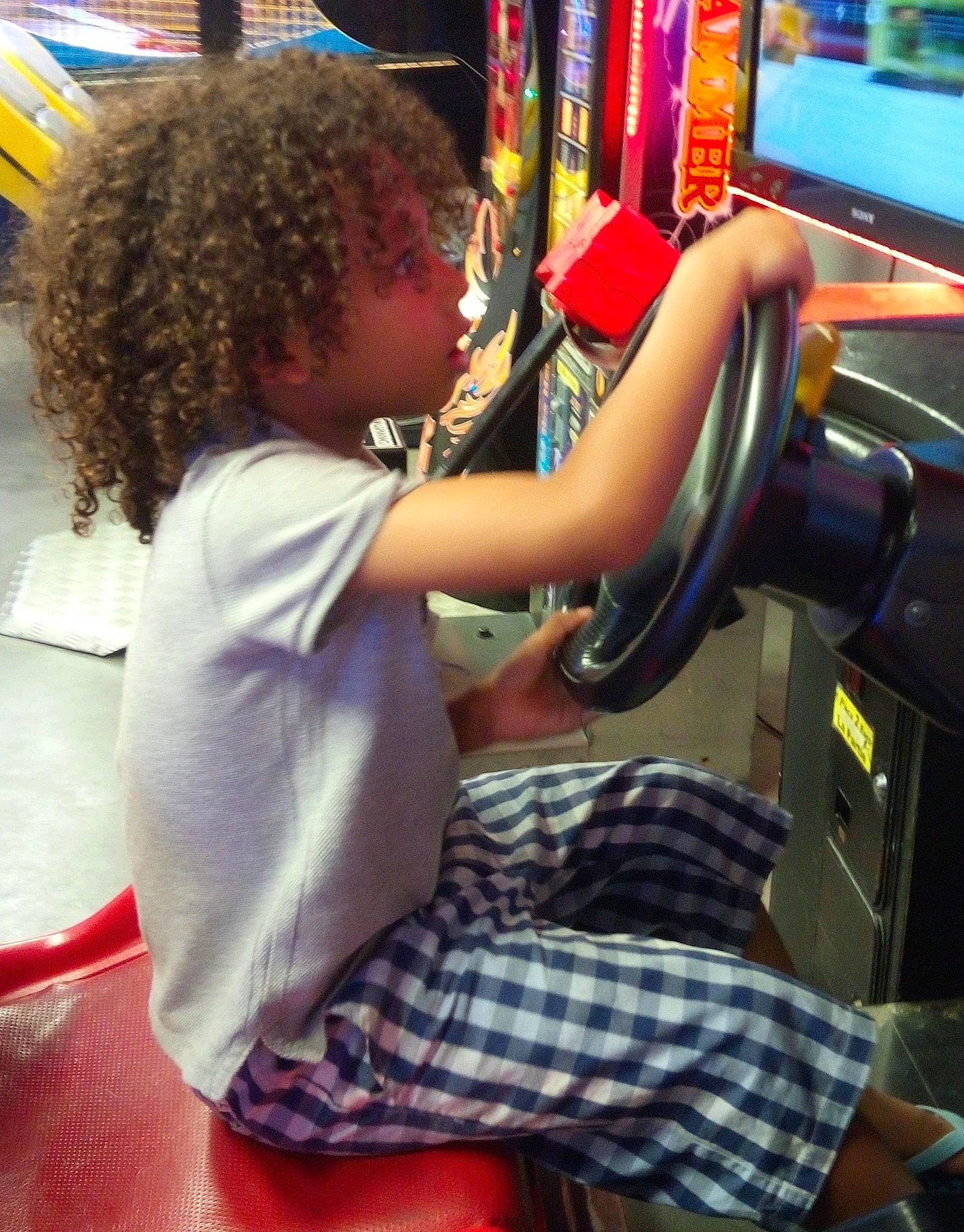 Haïley participe au concours pour gagner de l'argent avec cette photo : arm, audio_equipment, child, electronic_device, flooring, fun, hair, human_body, human_leg, leisure, long_hair, machine, person, play, shoulder, sitting, t_shirt, tartan, thigh, toddler