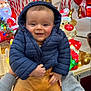 Nolan participe au concours pour gagner de l'argent avec cette photo : baby, child, smiling, puffy_jacket, hood, festive, holiday_decorations, reindeer, santa, lights, glowing, indoor, hands, warm_clothing, cute, portrait, celebration, winter, happy, person