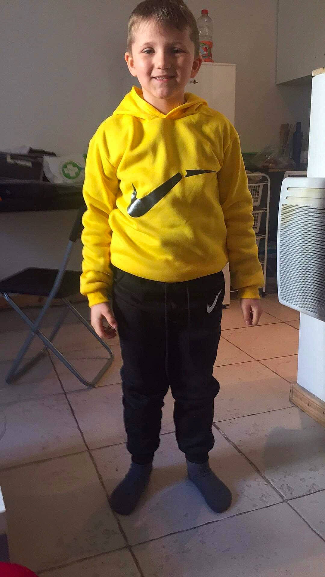 Gino participe au concours pour gagner de l'argent avec cette photo : child, costume, high_visibility_clothing, jacket, joy, outerwear, person, personal_protective_equipment, sleeve, standing, t_shirt, yellow