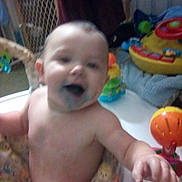 Adam joined the competition — help win amazing prizes! baby, child, blue_mouth, smiling, happy, indoor, play_area, toys, blanket, infant, person, cute, chubby_cheeks, young_child, colorful, playtime, soft_toys, expression, reaching_out, blurred