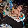 baby, walker, toy, table, plate, clutter, baby_gate, indoor, child, furniture, colorful, room, household_items, person, infant, blur, reaching, plastic, seat, floor