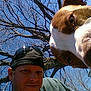 Achilles is registered to the contest to win money with this photo: animal, branches, brown, canine, cap, casual, daylight, dog, face, headwear, man, nature, outdoor, pet, portrait, selfie, sky, sunglasses, tree, white