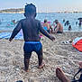 back_view, barefoot, beach, boats, child, family, holiday, outdoor, pebbles, people, relaxation, sand, sea, shore, sky, summer, swimwear, toddler, vacation, water