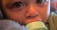 Skyler is registered to the contest to win money with this photo: baby, blanket, blue, bottle, close_up, comfort, cute, expression, eyes, face, feeding, head, indoors, infant, milk, nurture, person, skin, soft_texture, young_child