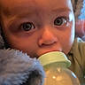 baby, bottle, milk, blanket, close_up, face, infant, feeding, soft_texture, blue, expression, cute, young_child, indoors, skin, head, eyes, person, comfort, nurture