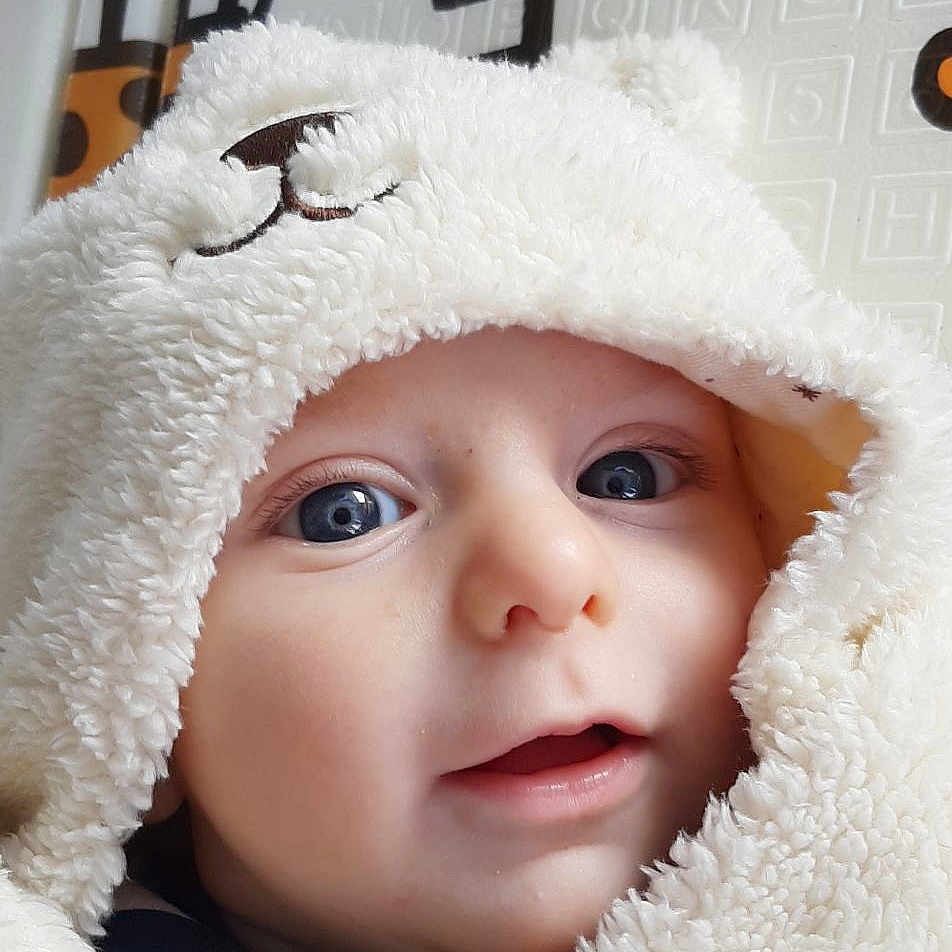 Nino a rejoint le concours — aidez-le/la à gagner de superbes lots ! baby, blanket, bonnet, cap, clothing, coat, face, happy, hat, head, hood, hoodie, jacket, knitwear, person, photography, portrait, smile, sweater, sweatshirt